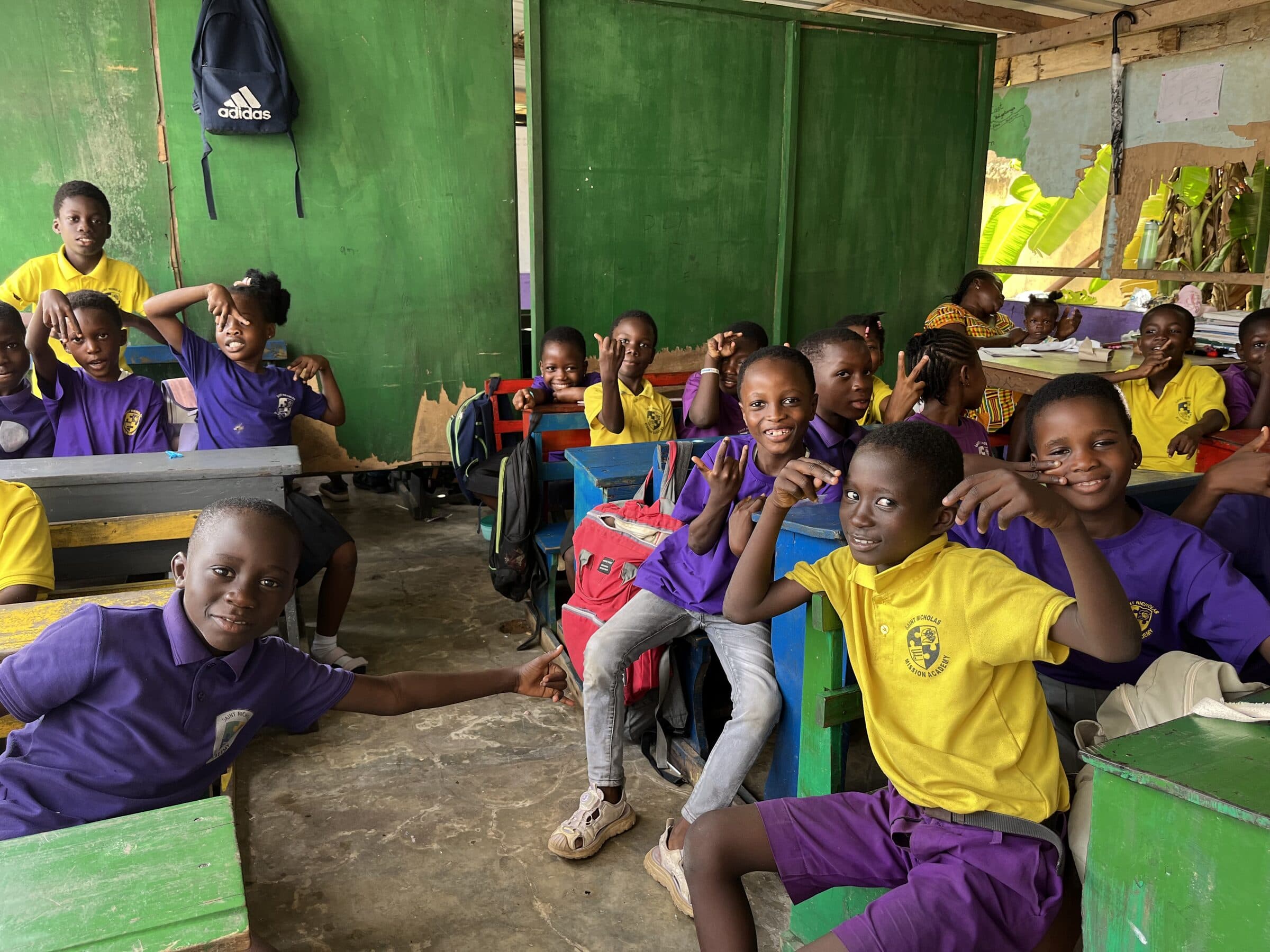 A volunteer working with students at a Crowdwave Ghana partner school